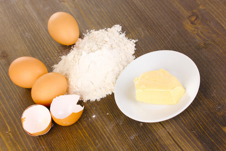 鸡蛋 面粉和黄油的特写，木桌上