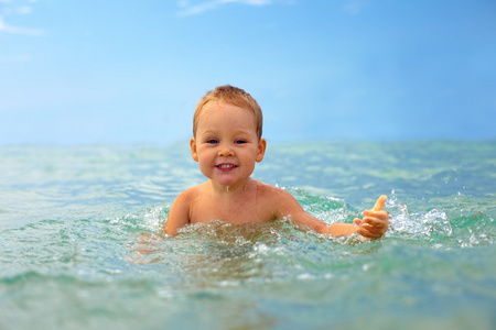 可爱笑脸婴儿男孩开心玩海水