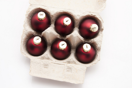 六包盒鸡蛋与孤立在白色背景上的红色圣诞球