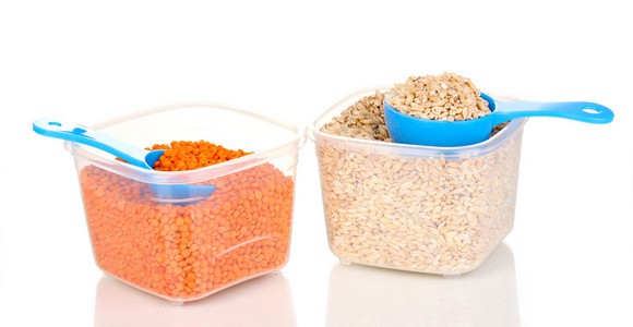 测量勺子和谷物孤立在白色的塑料容器