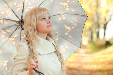 有一把伞在秋天公园的女孩