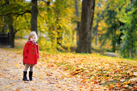 明亮的红色外套，在秋季的小女孩