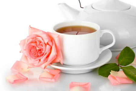 茶壶与杯茶与孤立在白色的玫瑰