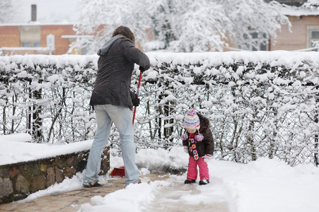 蹒跚学步的女孩和她的父亲在一个冬日