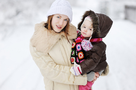蹒跚学步的女孩和她的母亲在一个冬日