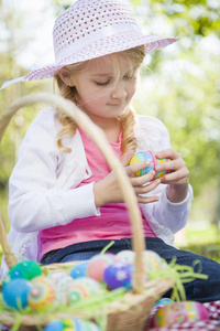 戴帽子的可爱小女孩喜欢吃复活节彩蛋