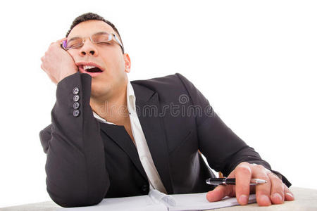疲惫的商人睡在办公桌旁打呵欠