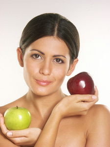 年轻女子在白色背景上持有两个新鲜的苹果