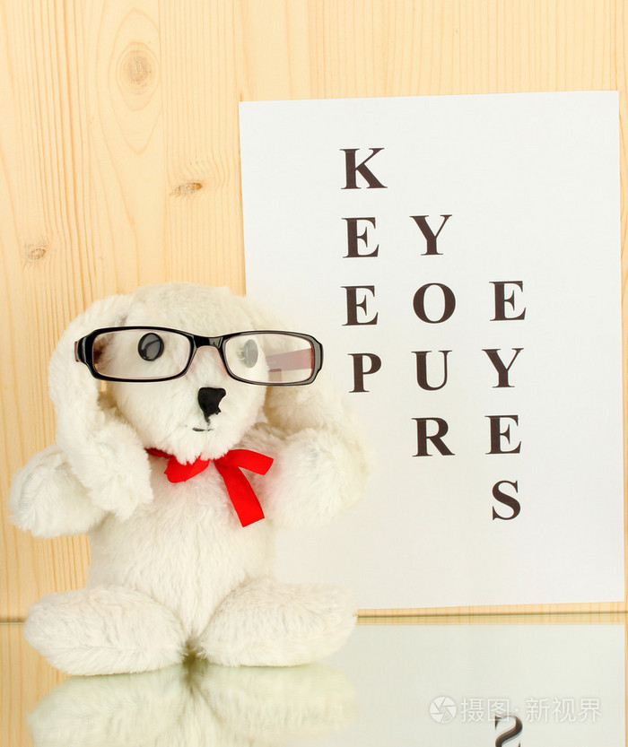 视力测试图与眼镜和玩具上木制背景特写