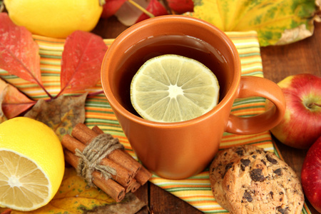 杯热茶和秋天的叶子，木桌上