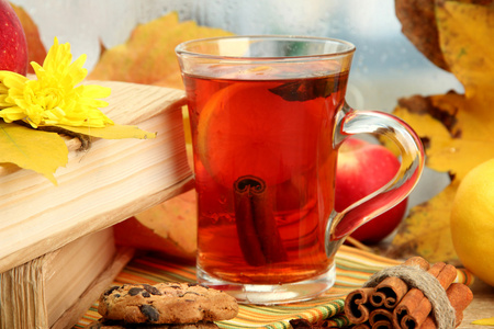 杯热茶和秋天的叶子，木桌上