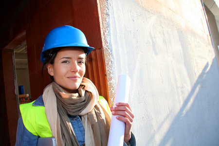 女人的建筑师站在建筑工地上