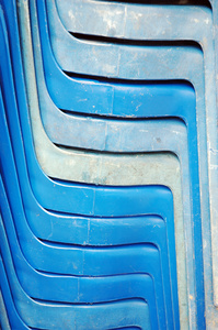 堆的旧蓝色塑料椅子