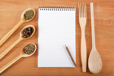 食谱和香料木桌上的笔记本