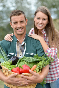 持有篮蔬菜的农民夫妇的肖像