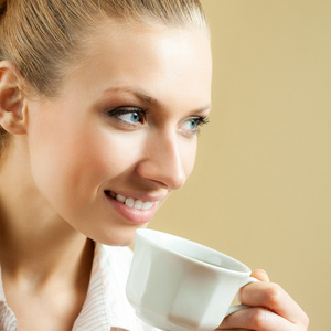 年轻女子在家里喝咖啡或茶，