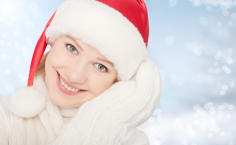 美容快乐的年轻女人在圣诞帽子和手套