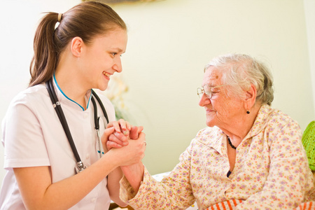 护士探访老人生病女人社交和她交谈，着她的手