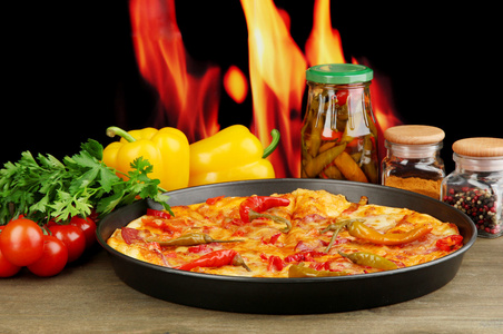 在泛用火焰背景上蔬菜美味意大利辣香肠比萨饼