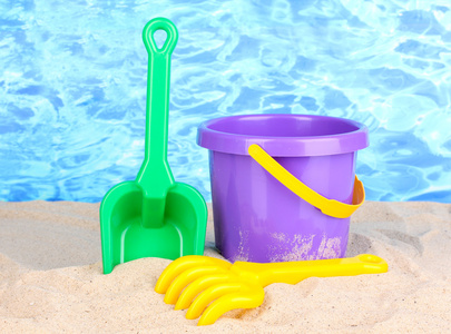 儿童沙滩玩具在沙子上水背景上