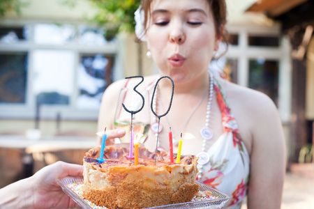 年轻女子吹熄生日蜡烛 30