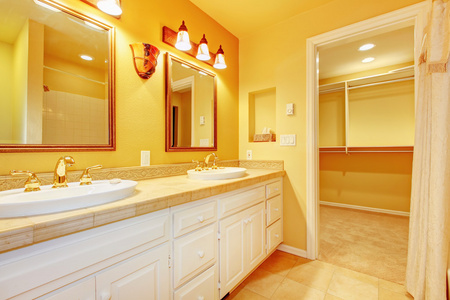 浴室配有白色柜和金黄色的墙