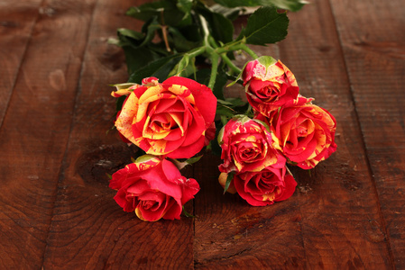 美丽的红黄色玫瑰上木制背景特写