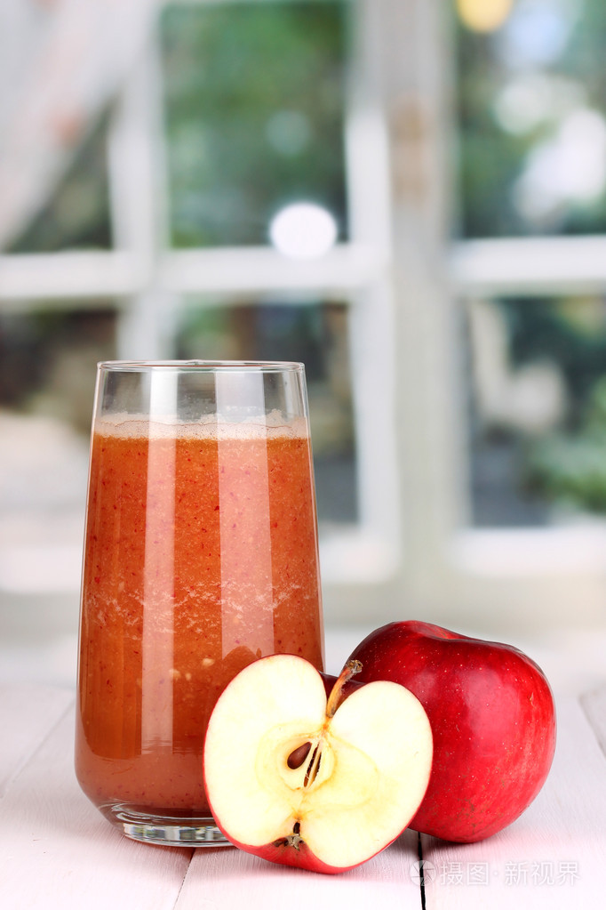 杯新鲜苹果汁木桌上,对窗口背景