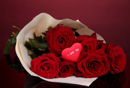 束美丽的红玫瑰与情人节红色背景上