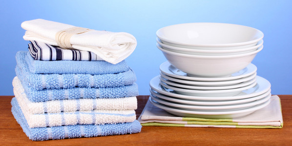 厨房毛巾的盘子上蓝色背景特写