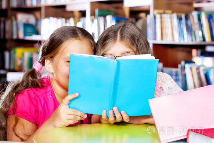 两个女孩读一本书