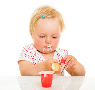可爱的婴儿女孩学习用勺子吃饭