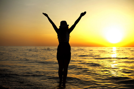 快乐的女人跳在海上日落