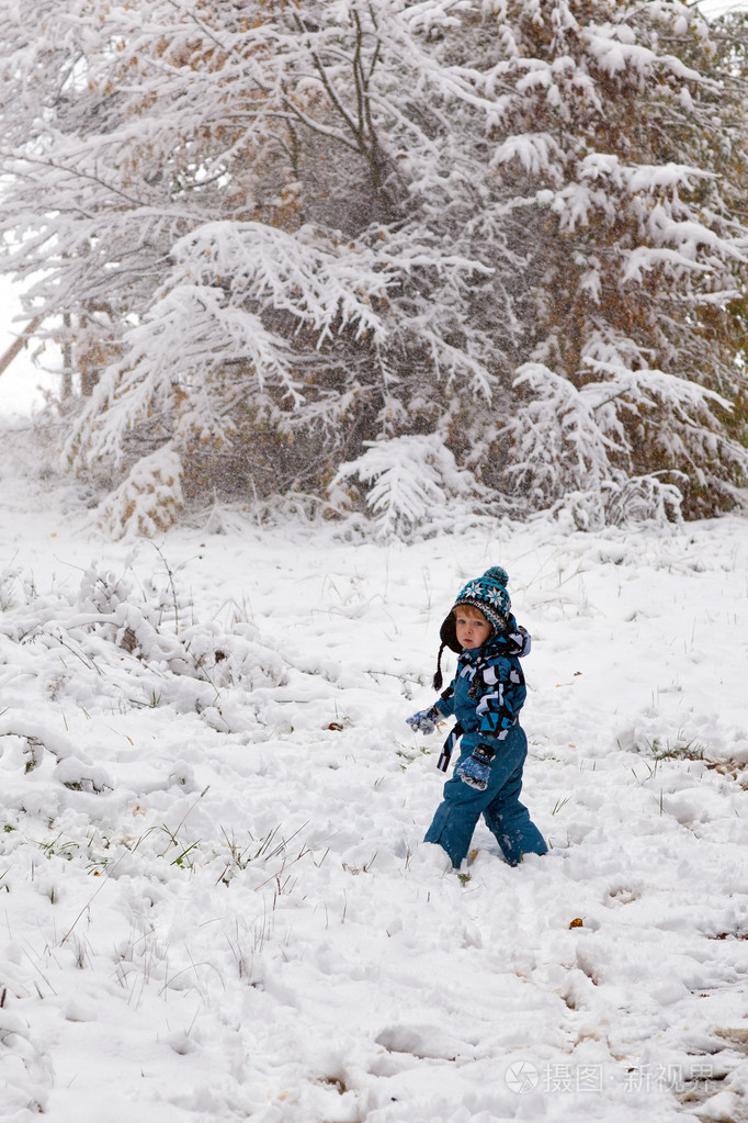 可爱的小孩男孩在冬季一天玩雪