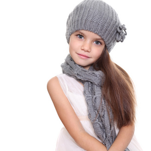 针织的帽子和灰色围巾的小女孩