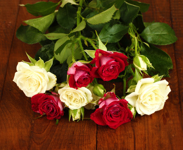 美丽的玫瑰上木制背景特写的花束