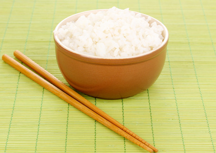 碗的米饭和筷子竹垫上