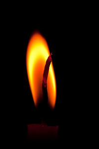 孤立在黑色背景上的蜡烛烧的特写