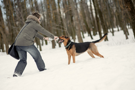 在雪地上玩狗的女孩