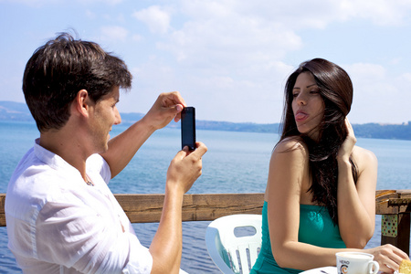 男人正在拍照的美丽的妻子在意大利湖