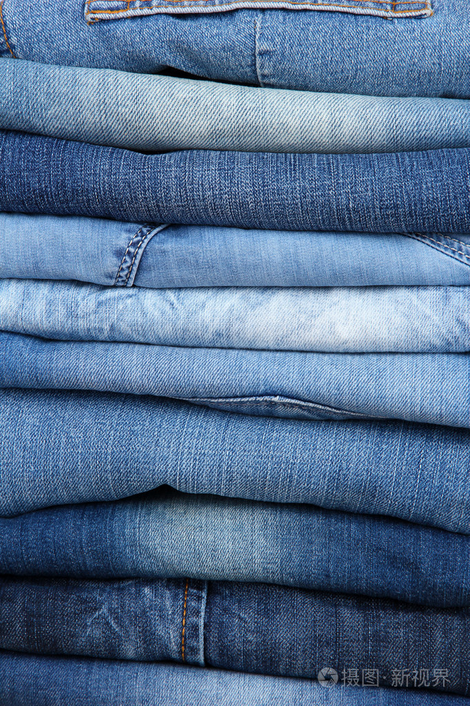 很多牛仔裤堆积在桩特写
