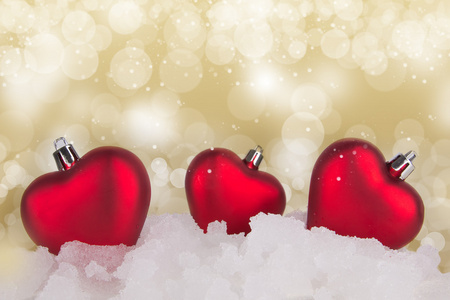 抽象圣诞黄金背景与在雪地上的红球
