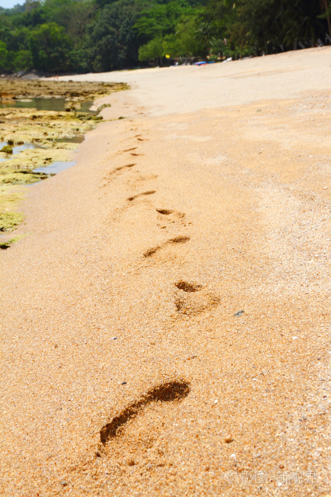 光着脚在沙滩的脚印