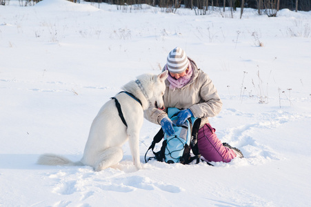 有一只狗在冬天在步行中的女人
