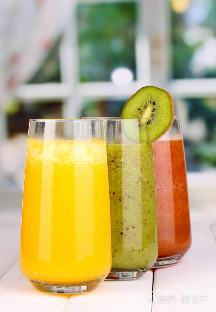 木桌上,在窗口的背景上的新鲜果汁