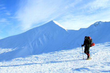 徒步旅行者在冬季山雪地行走图片