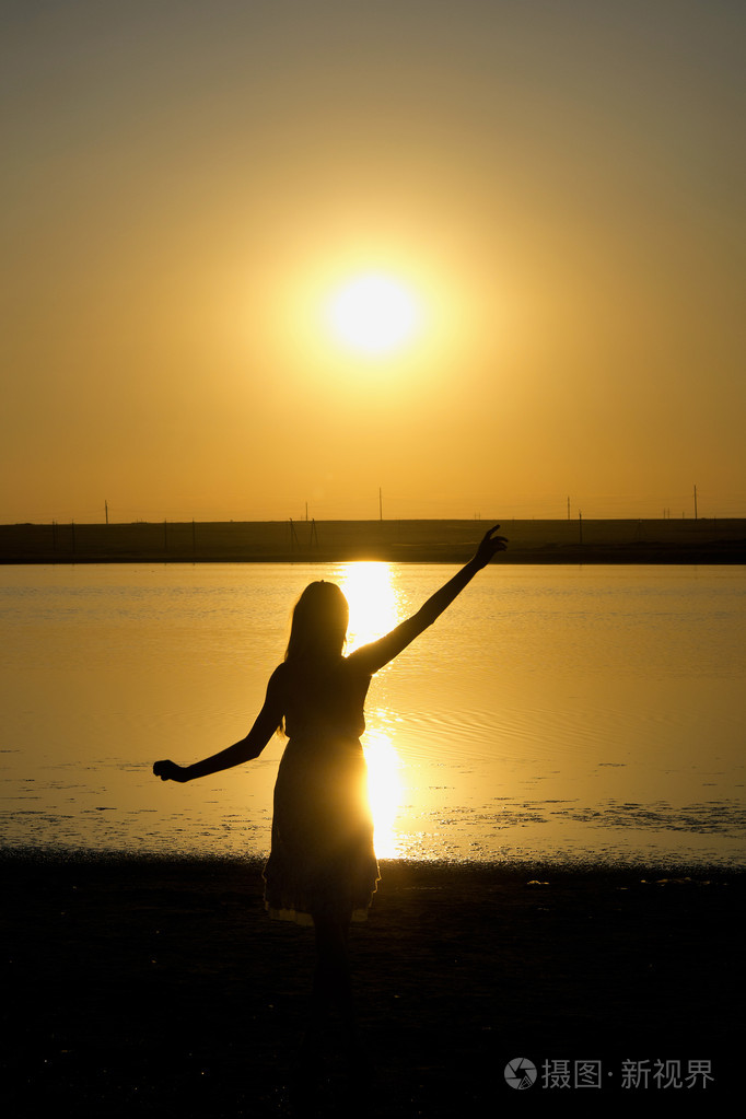 日落背景上跳舞女孩的侧面影像