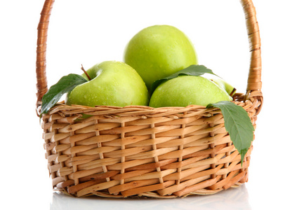 成熟的绿色苹果用叶子在篮子上白色隔离