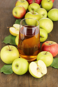 有用的苹果汁与周围木桌上的苹果