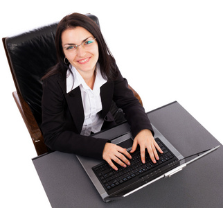 坐在笔记本电脑上工作的快乐年轻女商人